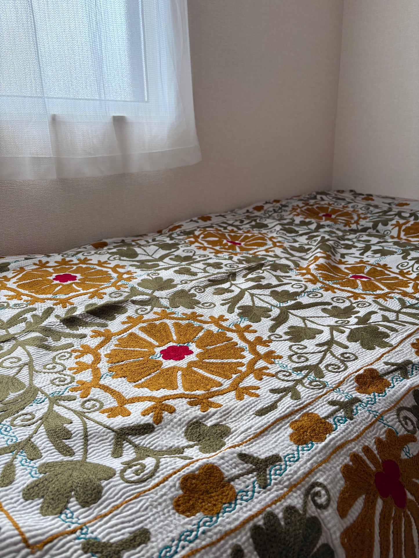 マスタード色のカーネーションが特徴のスザニ刺繍カンタキルト