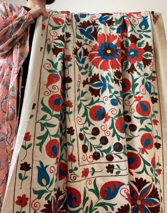 白い生地にかわいらしい雰囲気のスザニ刺繍が施された1枚です。ザクロやカーネーションなどの定番で人気のスザニ刺繍が施されています