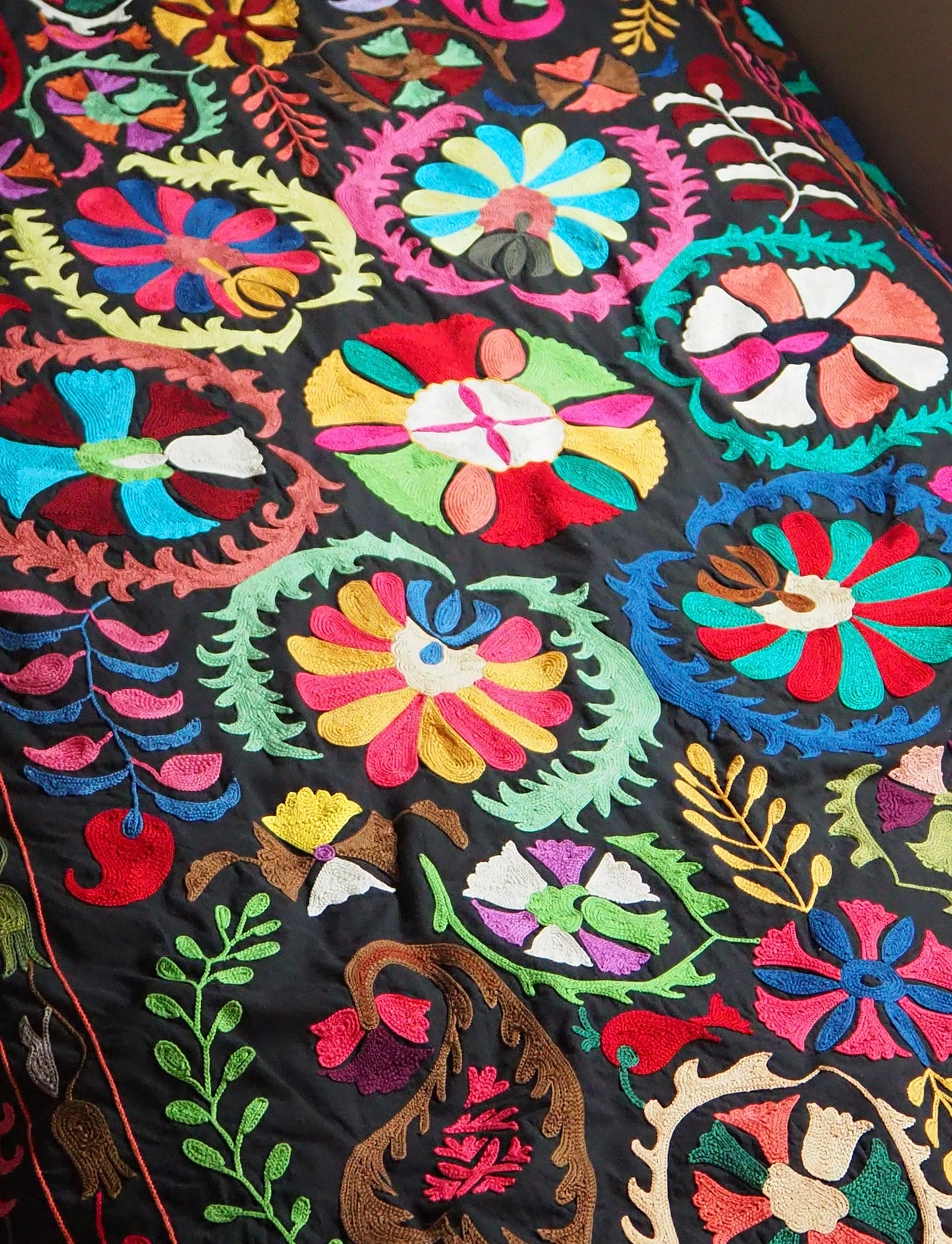 黒い生地に色鮮やかなデザインが素敵なスザニ刺繍です。手刺繍ですが1つ1つがとても素晴らしい手仕事で中央の太陽モチーフのデザインが美しいです